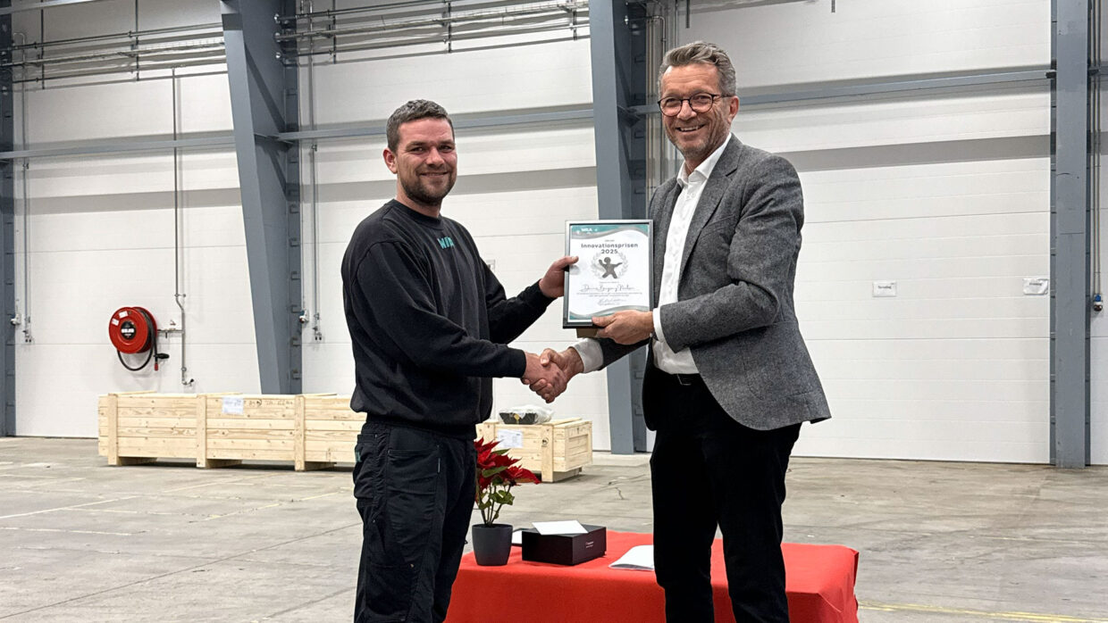 CEO Stig Krogh Pedersen presents the WILA Innovation Award 2025 to Dennis Bergsang during the annual holiday event.